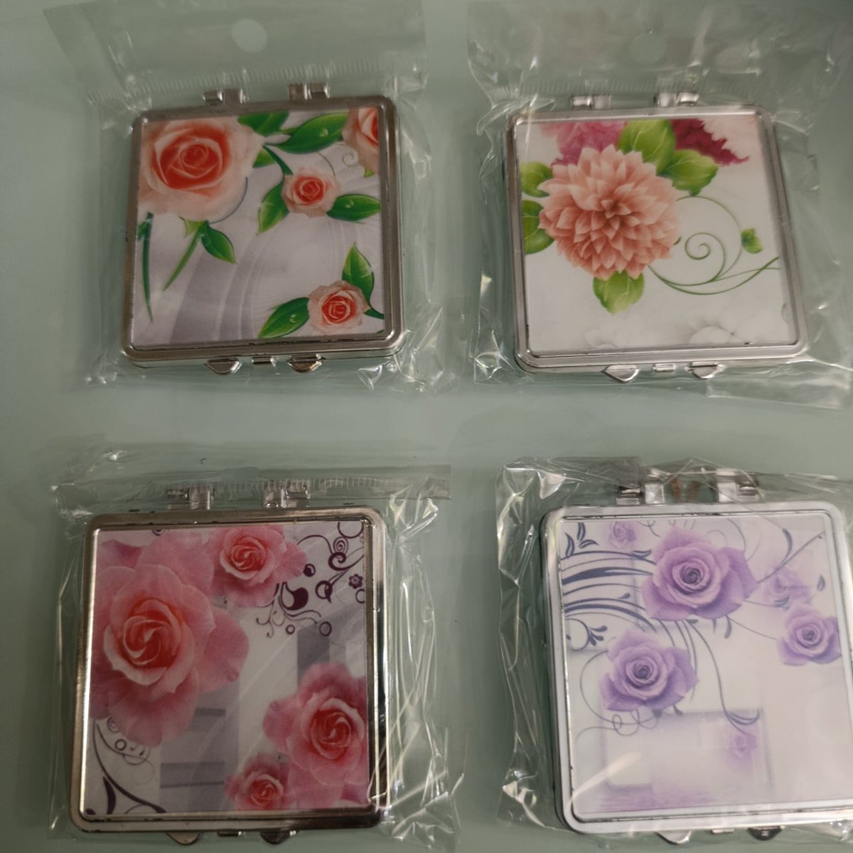 CAJITA CON ESPEJO DE BOLSILLO PARA DAMA DISEÑOS FLORALES CON 60 PZA POR MAYOREO