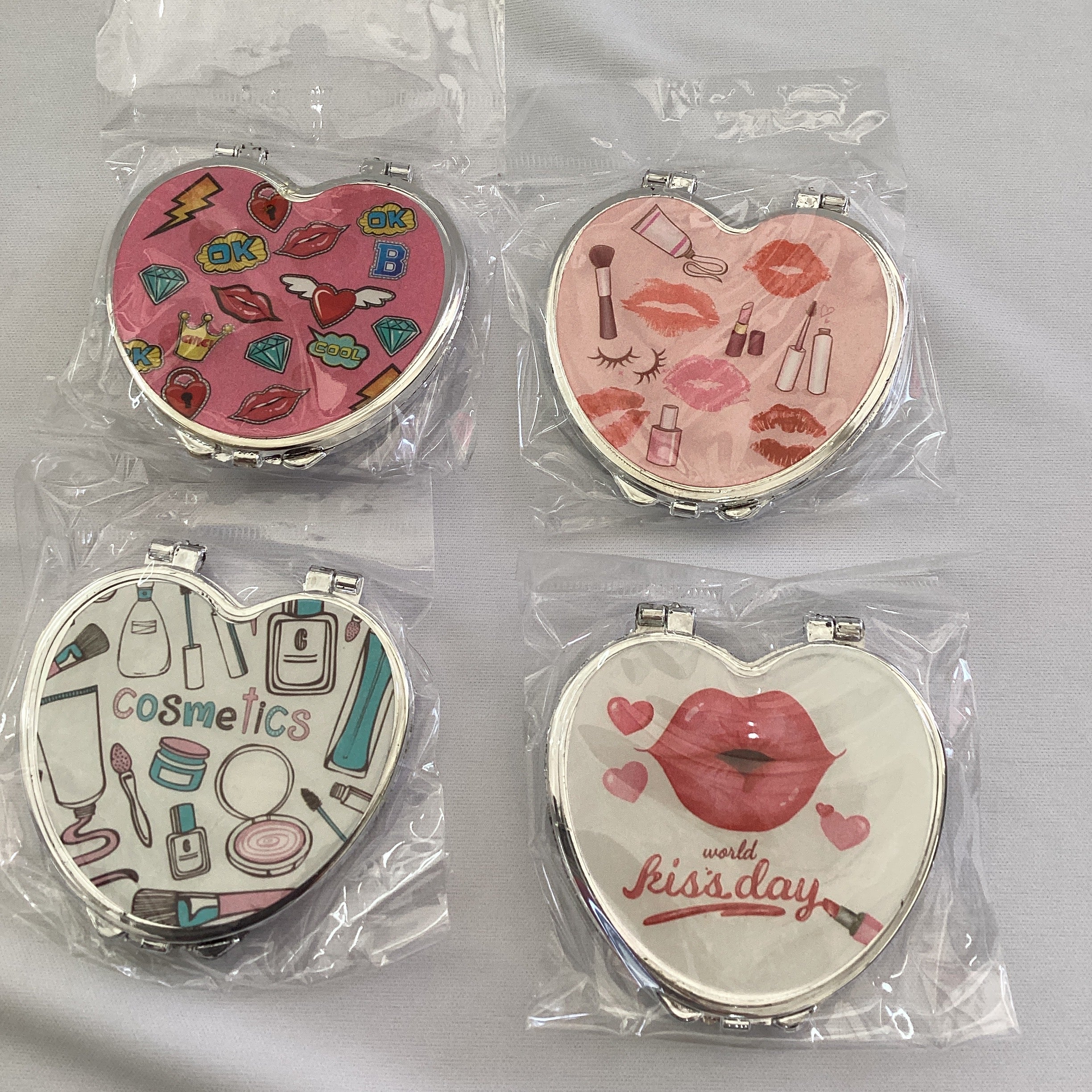 ESPEJO DE BOLSILLO FORMA DE CORAZÓN SURTIDO EN DISEÑOS Y COLORES POR MAYOREO